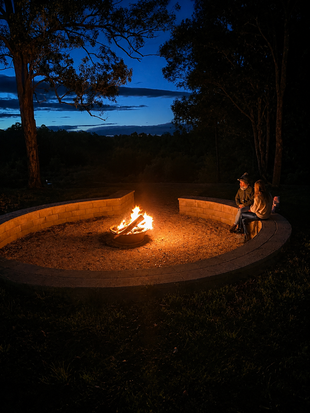 Wedding guests gathered around the fire pit at dusk on the paddocks at Adeline Estate