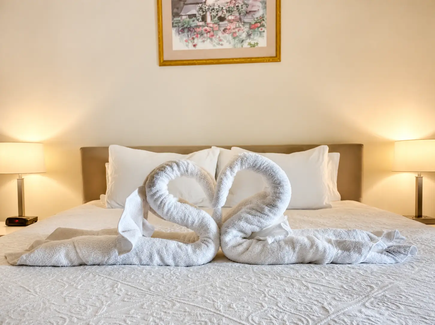Farmhouse bedroom with towel swans on the bed at Adeline Estate