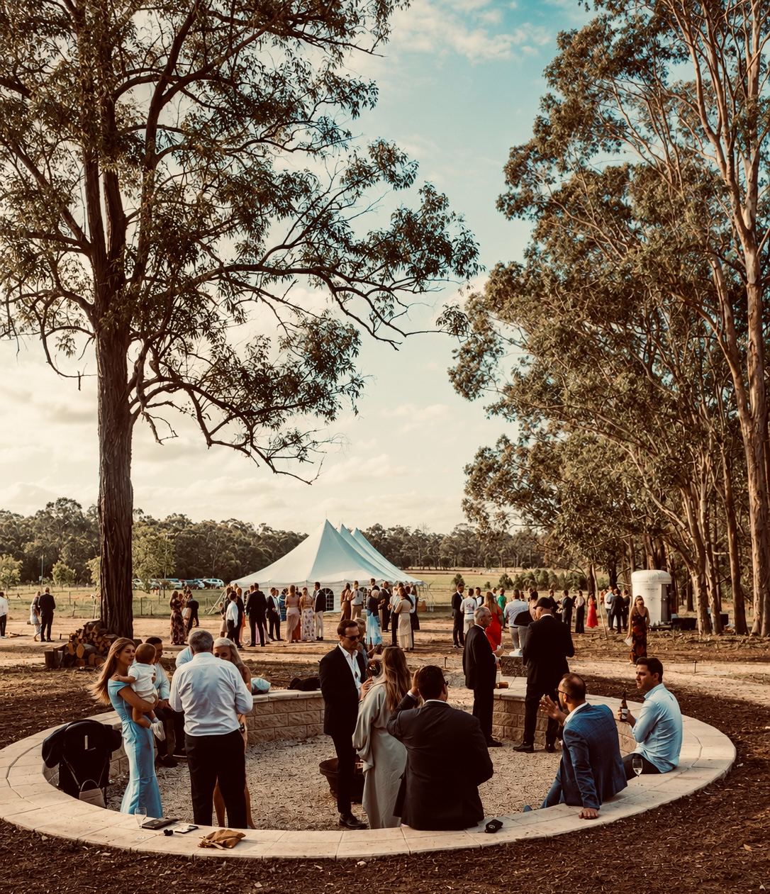 Wedding guests standing in a circle with drinks during cocktail hour