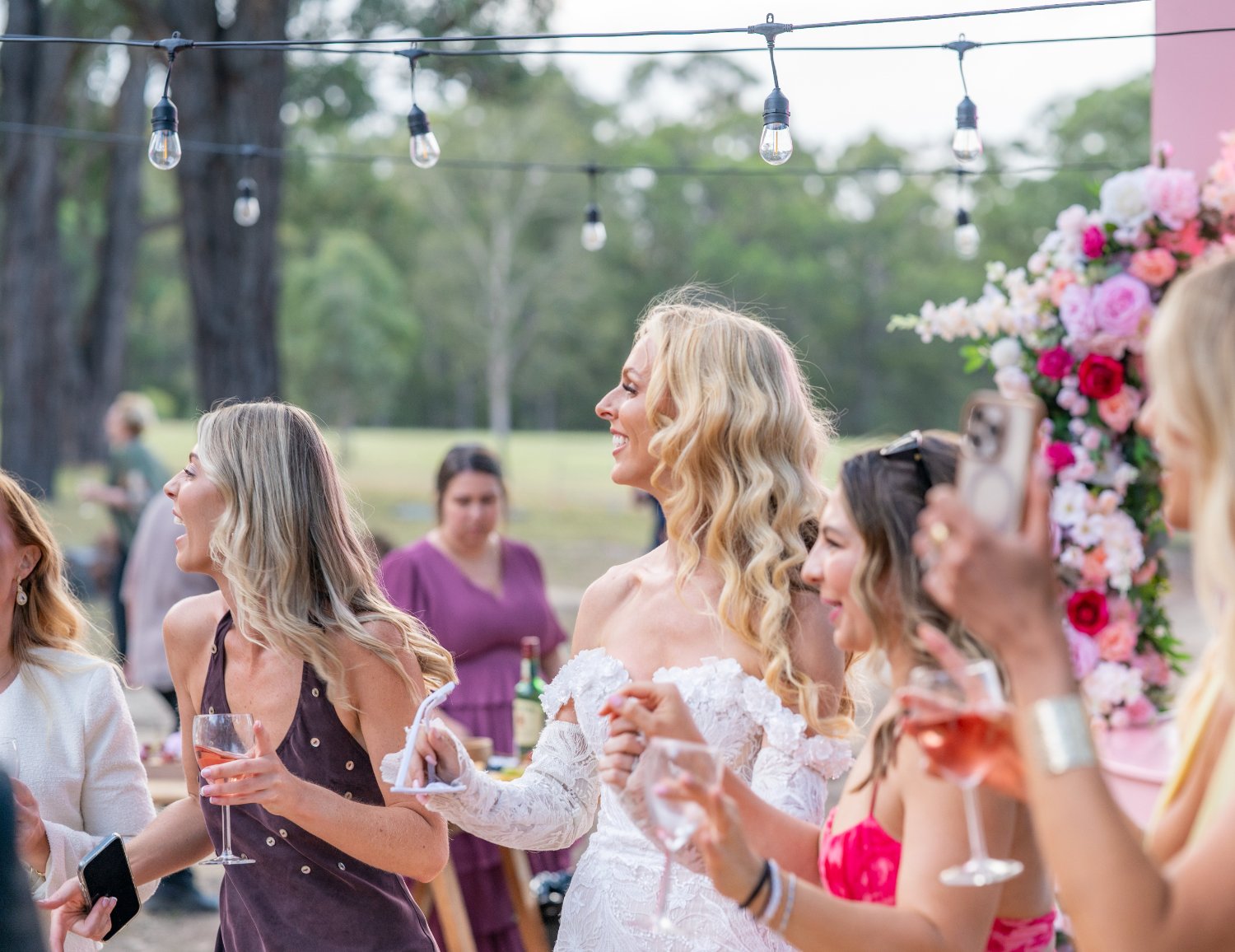 A guest laughing under festoon lights in the evening