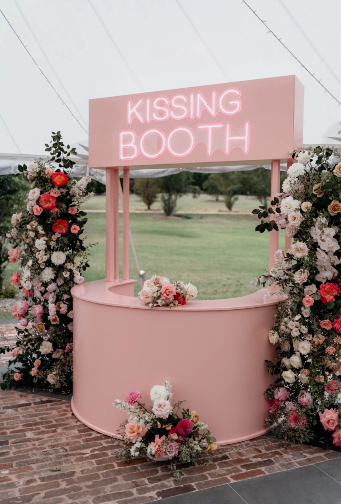 A kissing booth decorated with florals among the trees