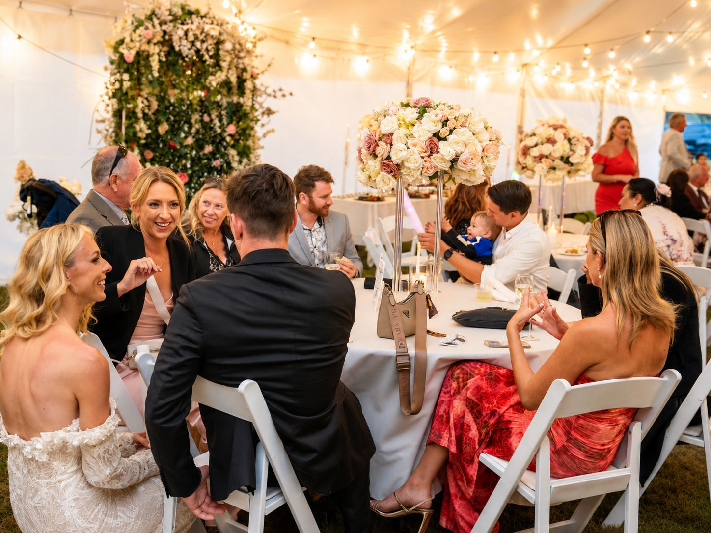 Guests seated at a long reception table, laughing over dinner