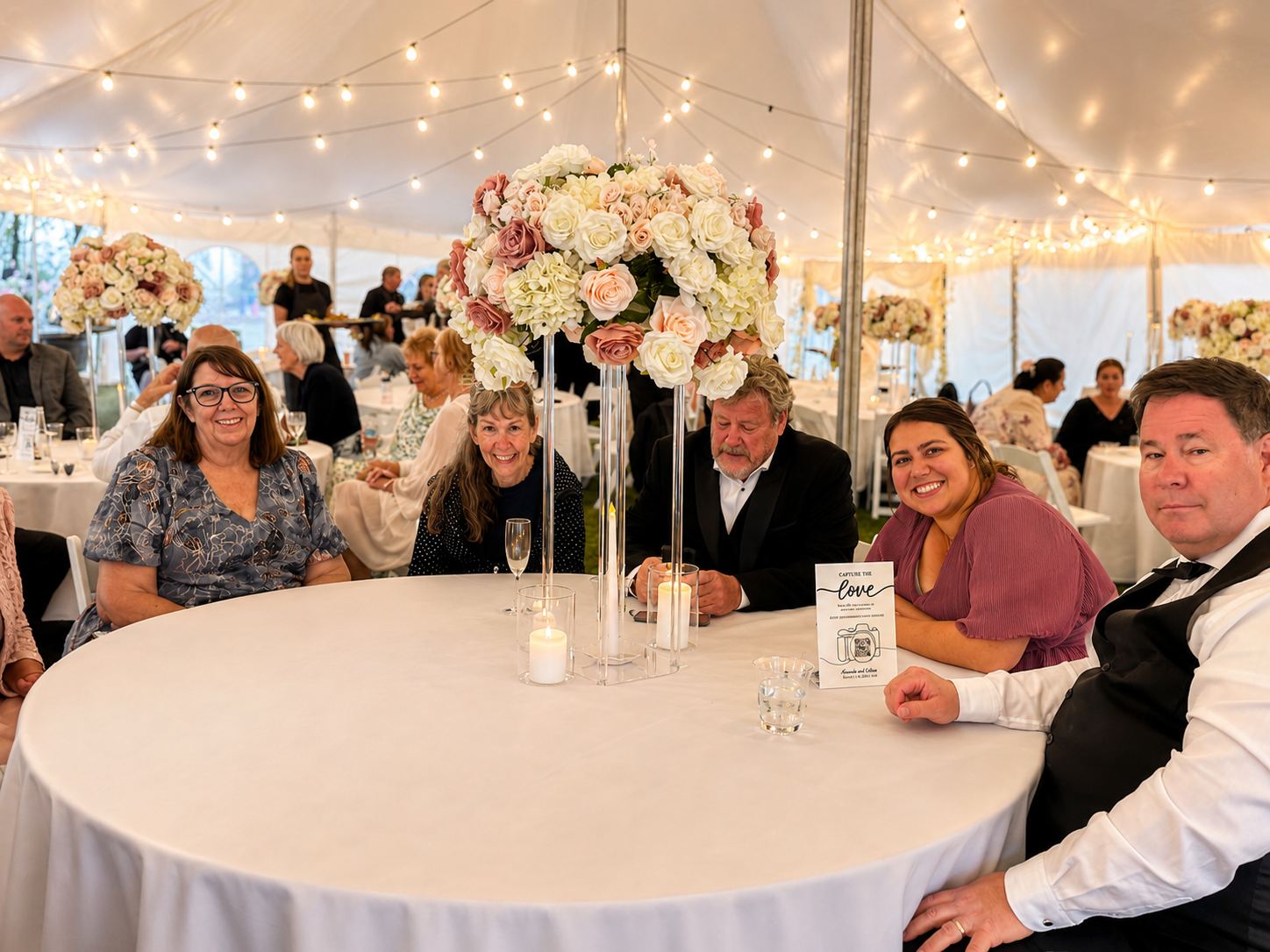 A reception table styled with florals under the marquee