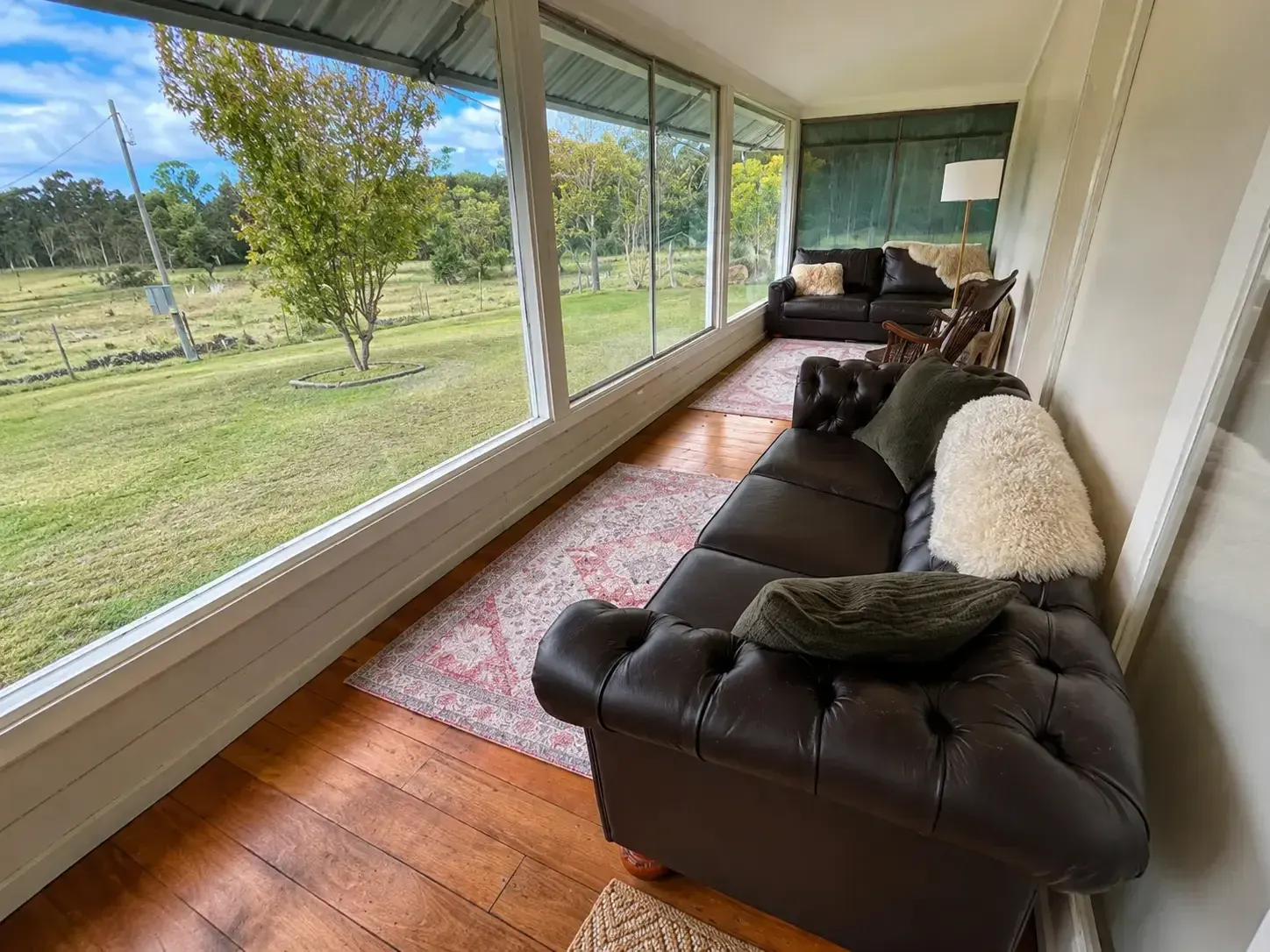 Farmhouse sunroom with leather lounge and paddock views